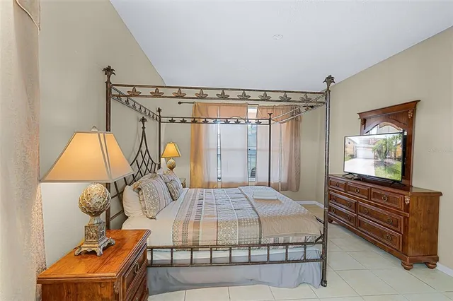 a bedroom with a bed and a flat tv screen on the dresser