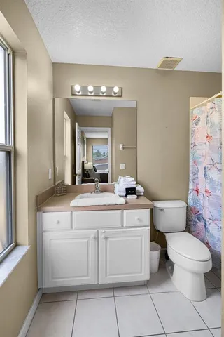 a spacious bedroom with a bed and wooden floor