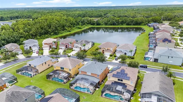 a view of a patio with couches table and chairs under an umbrella