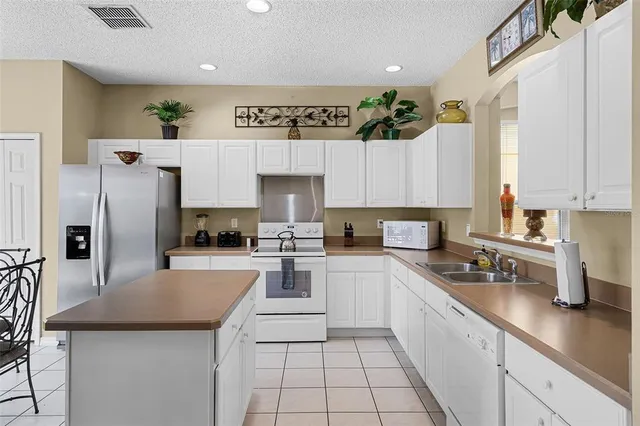 a kitchen with a sink a refrigerator and cabinets