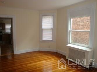 574 Scotland Road Orange, NJ 07050 - Photo 4 of 10 a view of an empty room with wooden floor and a window