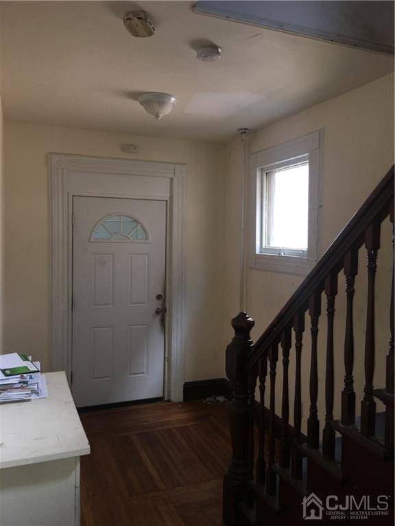 574 Scotland Road Orange, NJ 07050 - Photo 6 of 10 a view of a hallway to a livingroom with wooden floor and stairs