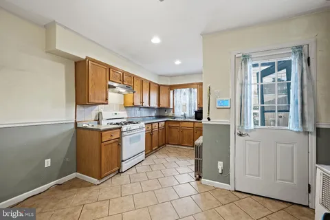 a large kitchen with stainless steel appliances granite countertop a refrigerator and a sink