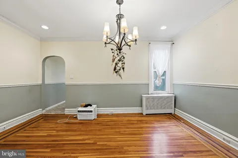 a view of a room with wooden floor and chandelier