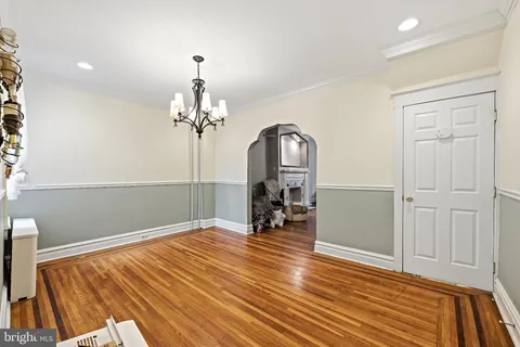 a view of a room with wooden floor staircase and a chandelier