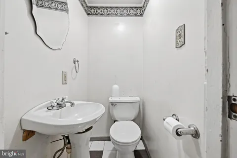 a bathroom with a sink a toilet and a mirror