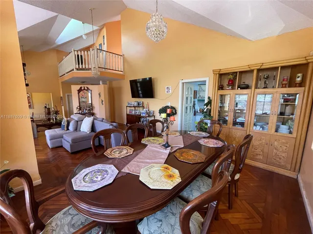 a kitchen with stainless steel appliances granite countertop table chairs and a refrigerator