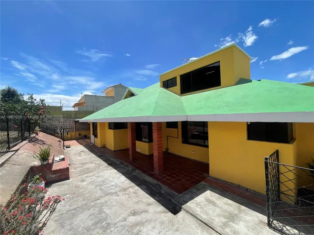 a view of a house with a yard and a fire pit