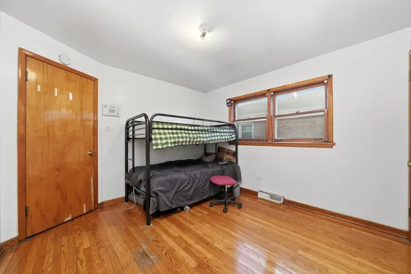 a bedroom with a bed and wooden floor