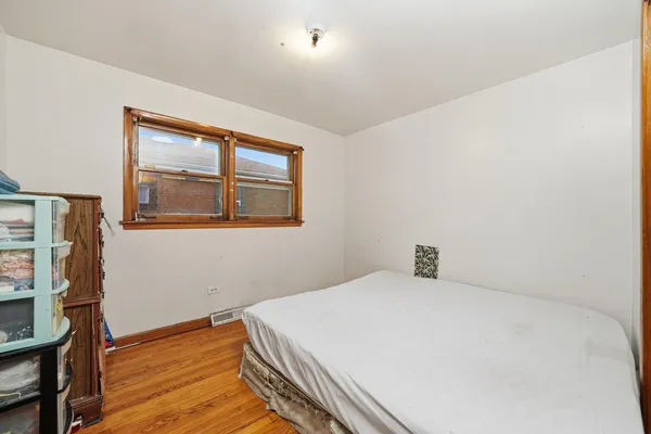 a bedroom with a bed and a refrigerator