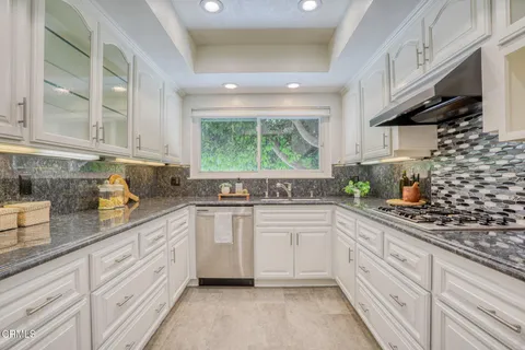 a kitchen with cabinets appliances a sink and a window