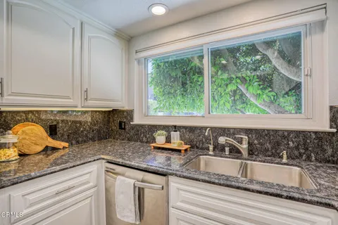 a kitchen with granite countertop a sink and a window