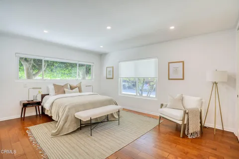 a bedroom with a bed a mirror and a window