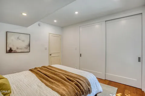 a bedroom with a large bed and a painting on the wall