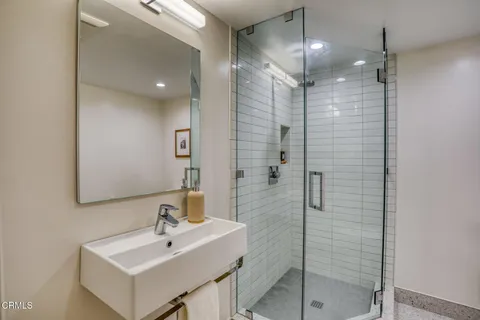 a bathroom with a sink a mirror and shower