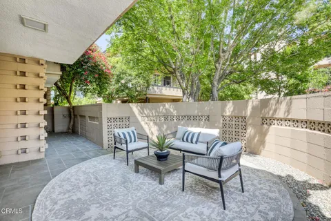 a view of patio with a table and chairs and potted plants