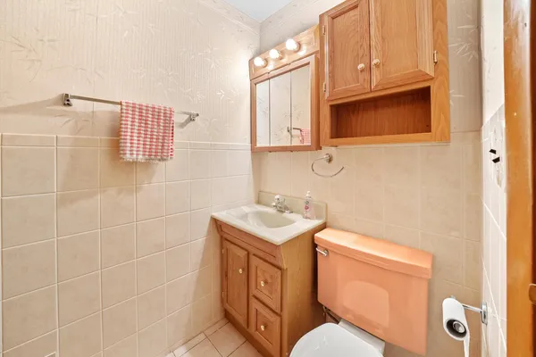 a bathroom with a toilet sink vanity and mirror
