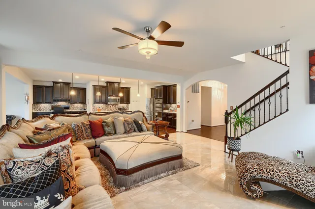 a kitchen with stainless steel appliances granite countertop a refrigerator a stove top oven a sink dishwasher a dining table and chairs with wooden floor