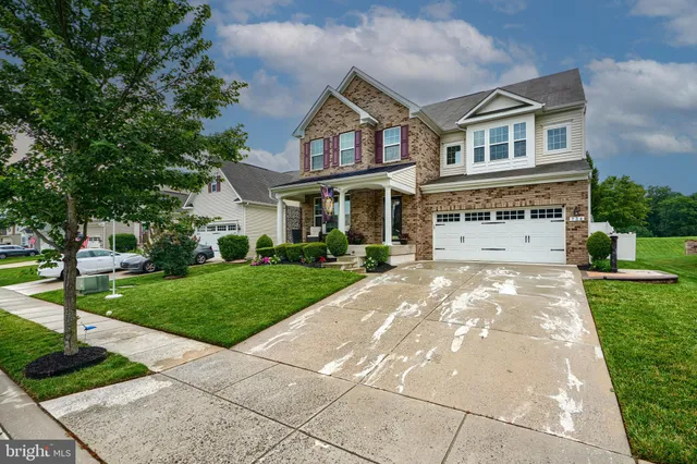 a front view of a house with a yard and trees