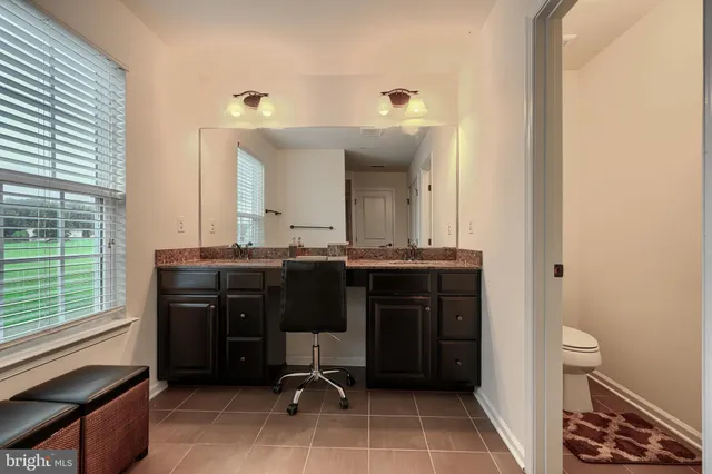 a living room with furniture a flat screen tv and kitchen view
