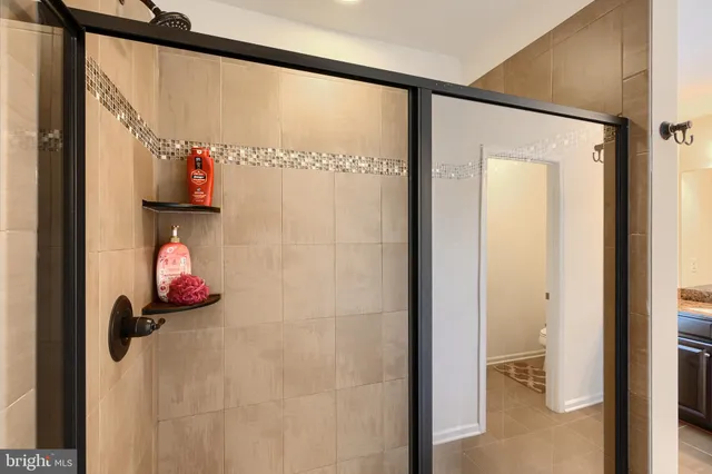 a living room with furniture a flat screen tv and kitchen view