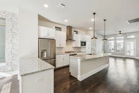 a kitchen with stainless steel appliances granite countertop a sink a stove and a refrigerator