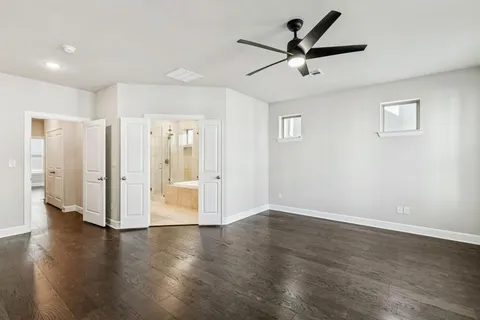 a view of empty room with wooden floor and ceiling fan