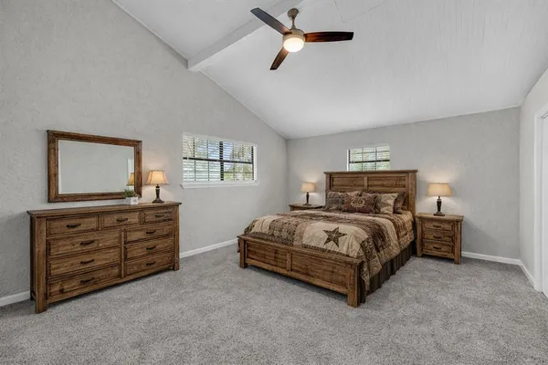 a spacious bedroom with a bed and a dresser