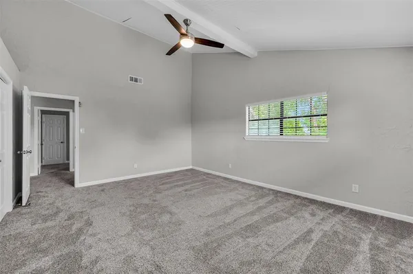 an empty room with windows and cabinet