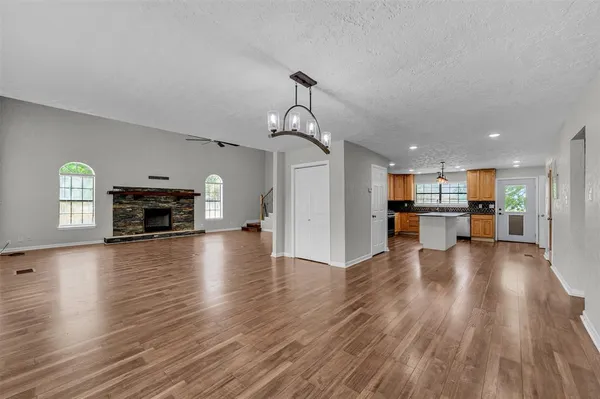 a view of empty room with wooden floor and a fireplace