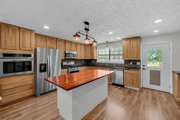 a kitchen with granite countertop stainless steel appliances and wooden cabinets