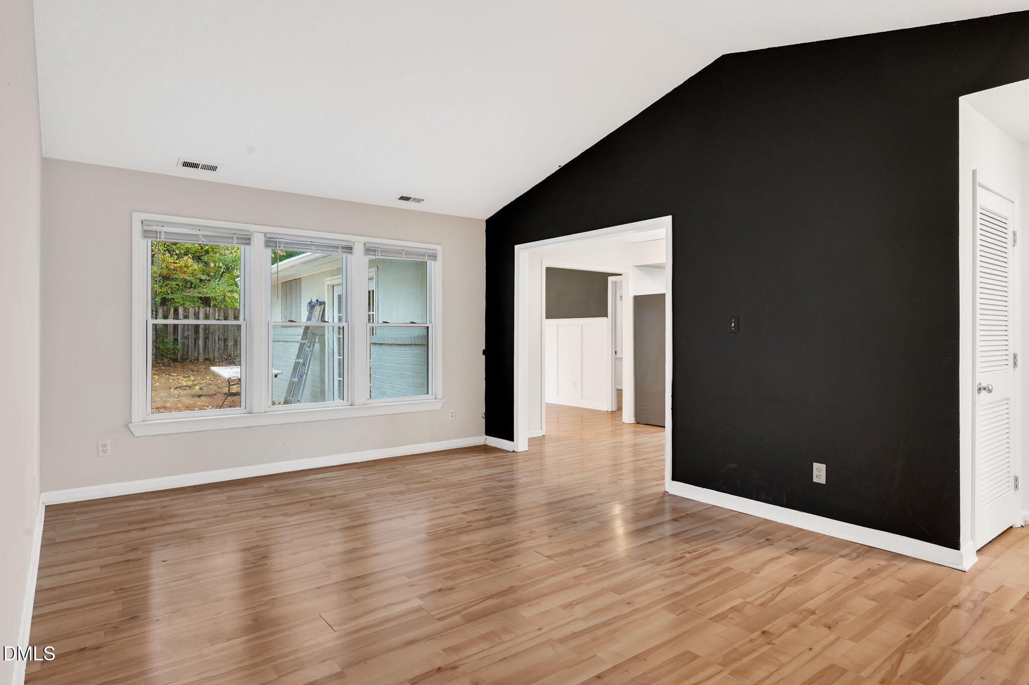 102 Castill Place Garner, NC 27529 - Photo 11 of 37 a view of an empty room with wooden floor and a window