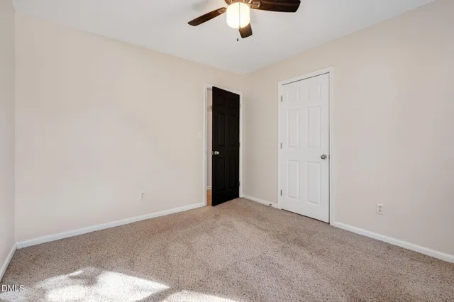 an empty room with a window and a ceiling fan