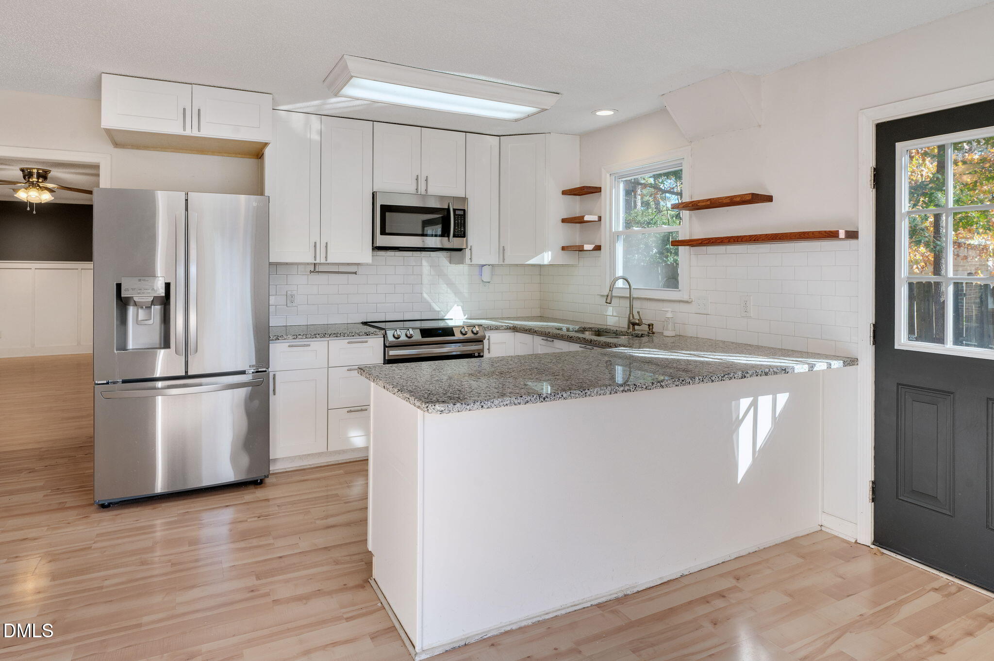 102 Castill Place Garner, NC 27529 - Photo 3 of 37 a kitchen with stainless steel appliances granite countertop a refrigerator a stove a sink a microwave a refrigerator and white cabinets with wooden floor