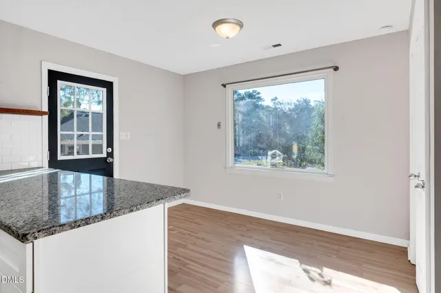 a kitchen with granite countertop a sink window and wooden floor