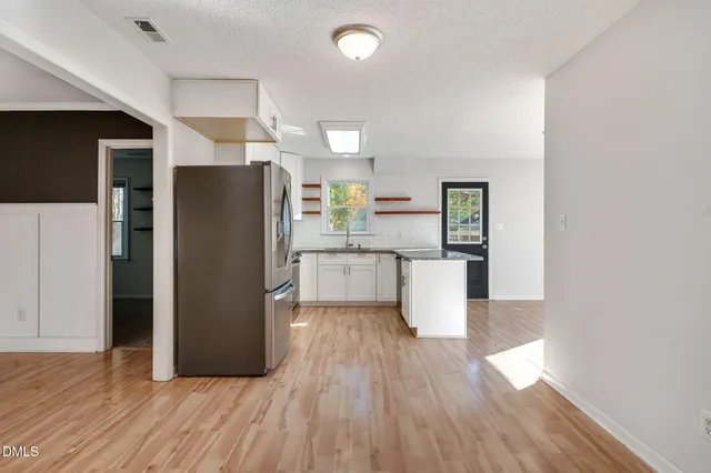 a kitchen with stainless steel appliances granite countertop a refrigerator a stove top oven a sink and dishwasher