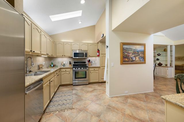 a kitchen with stainless steel appliances granite countertop a sink and a stove top oven