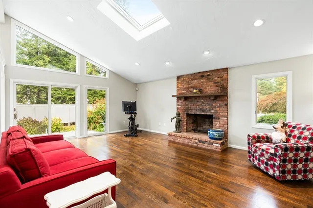 a living room with furniture a fireplace and a large window
