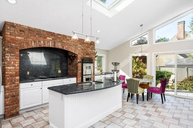 a kitchen with granite countertop a sink and a stove