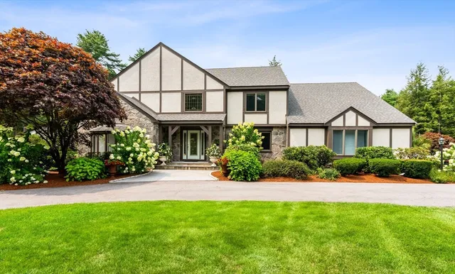 a front view of a house with a yard and potted plants