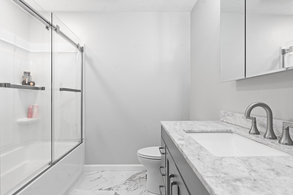 7 Saddle Ridge Road Sudbury, MA 01776 - Photo 32 of 42 a bathroom with a granite countertop sink a toilet and a shower