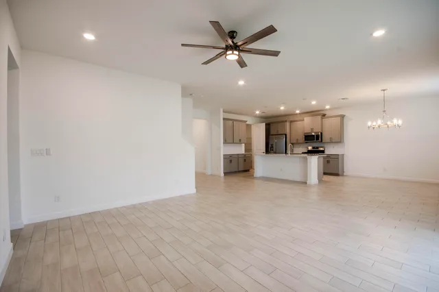 a view of a big room with kitchen wooden floor and a ceiling fan
