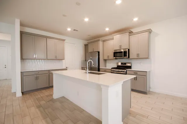 a kitchen with kitchen island white cabinets appliances and sink
