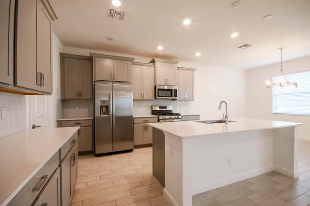 a kitchen with stainless steel appliances a refrigerator sink and microwave