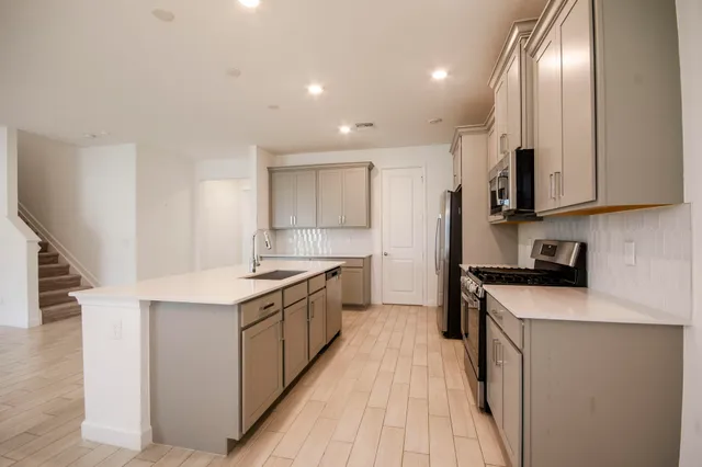 a kitchen with stainless steel appliances granite countertop a sink stove and refrigerator