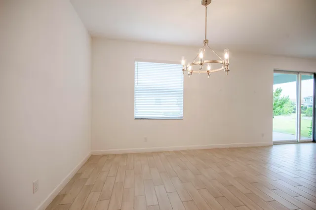 a view of a room with wooden floor and large windows
