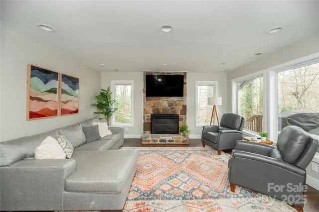 a living room with furniture a flat screen tv and a fireplace