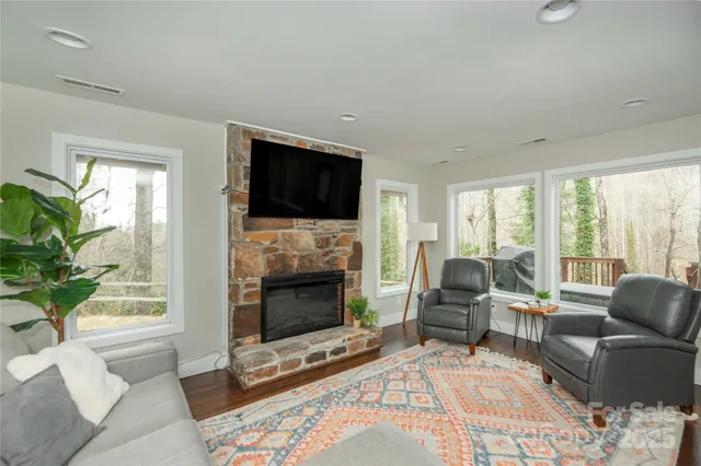 a living room with furniture a flat screen tv and a fireplace