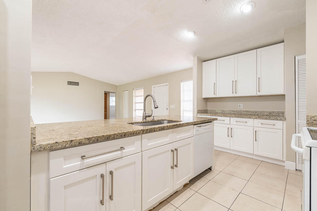 10225 Sleepy Brook Way Boca Raton, FL 33428 - Photo 12 of 41 a kitchen with granite countertop white cabinets and white appliances