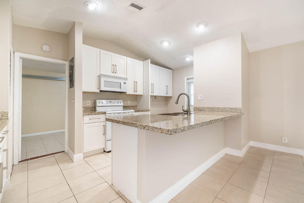 10225 Sleepy Brook Way Boca Raton, FL 33428 - Photo 16 of 41 a kitchen with stainless steel appliances granite countertop a sink and a stove